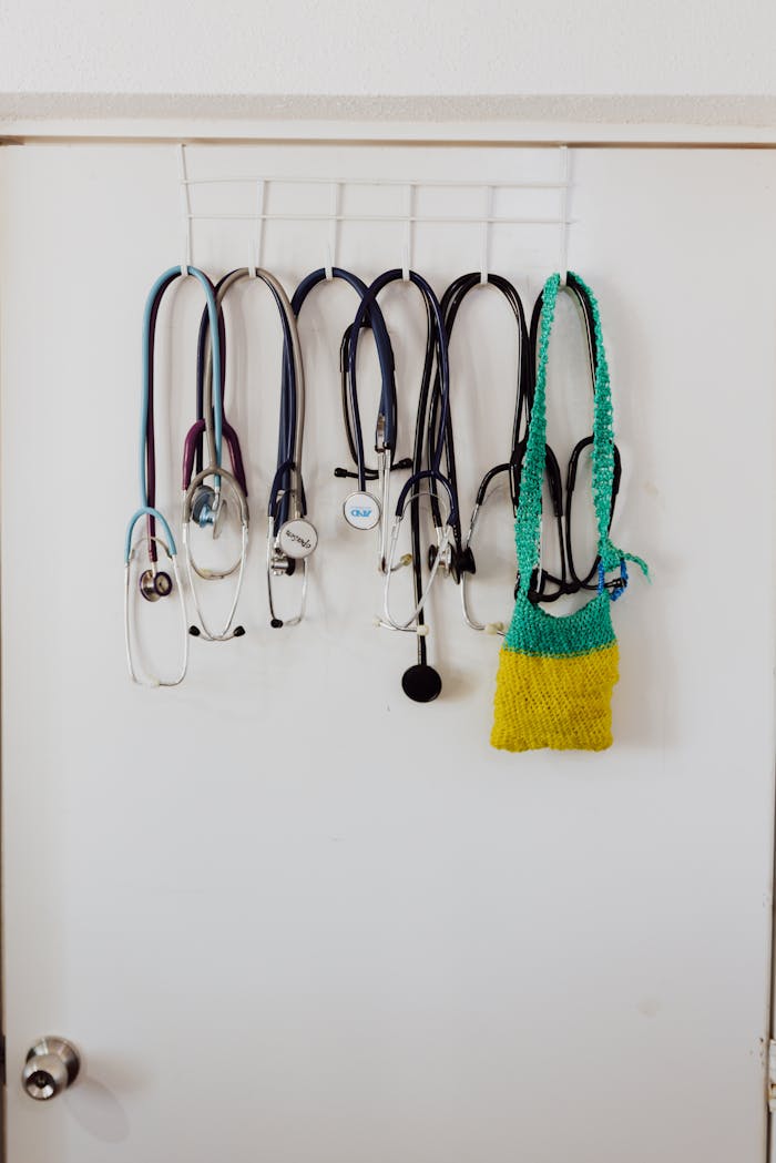 about-us-02 Multiple stethoscopes hang on door hooks, showcasing a medical setting.