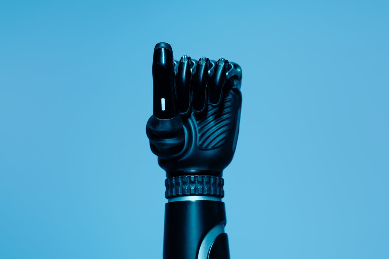about-us-01 Close-up of a prosthetic arm in a vibrant blue setting, showcasing advanced technology.