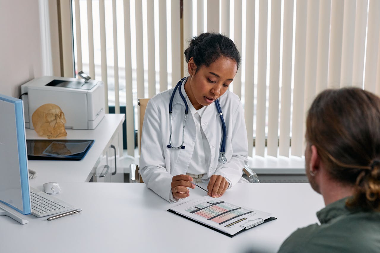 services-03 A doctor consulting with a patient in an office, discussing a medical chart.
